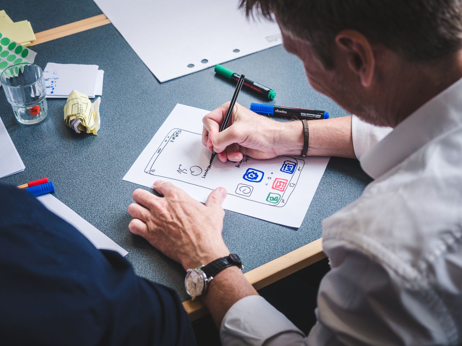 Paper wireframe sketches for a mobile app